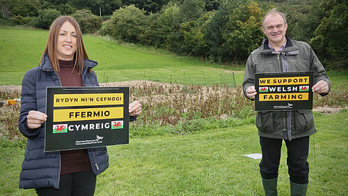Welsh Lib Dem Leader Jane Dodds and UK Leader Ed Davey holding signs saying "Back Welsh Farming"